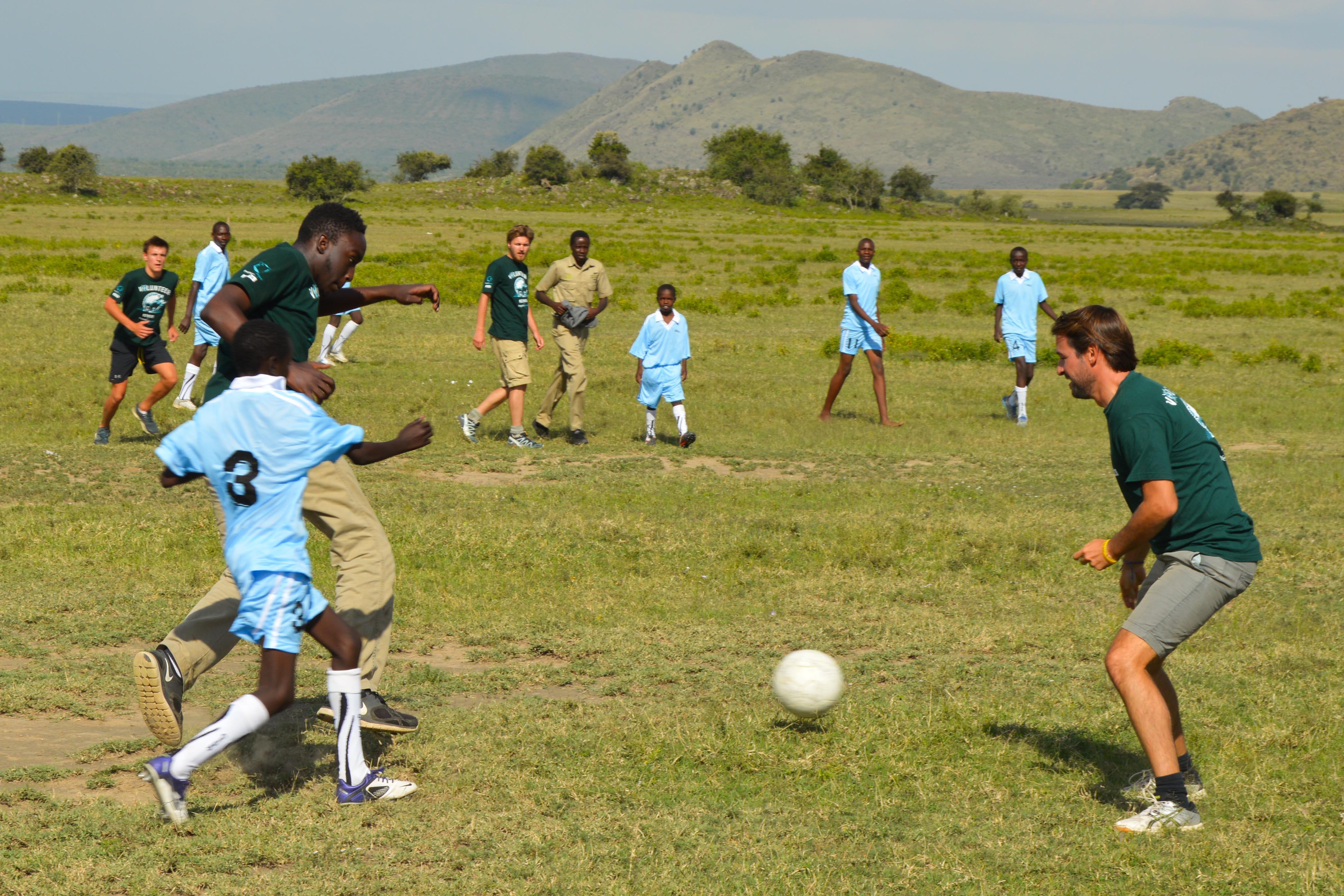 Projects Abroad volunteers play football with local children as part of their sports coaching abroad. Volunteers and local students playing football on one of our Sports volunteering opportunities.